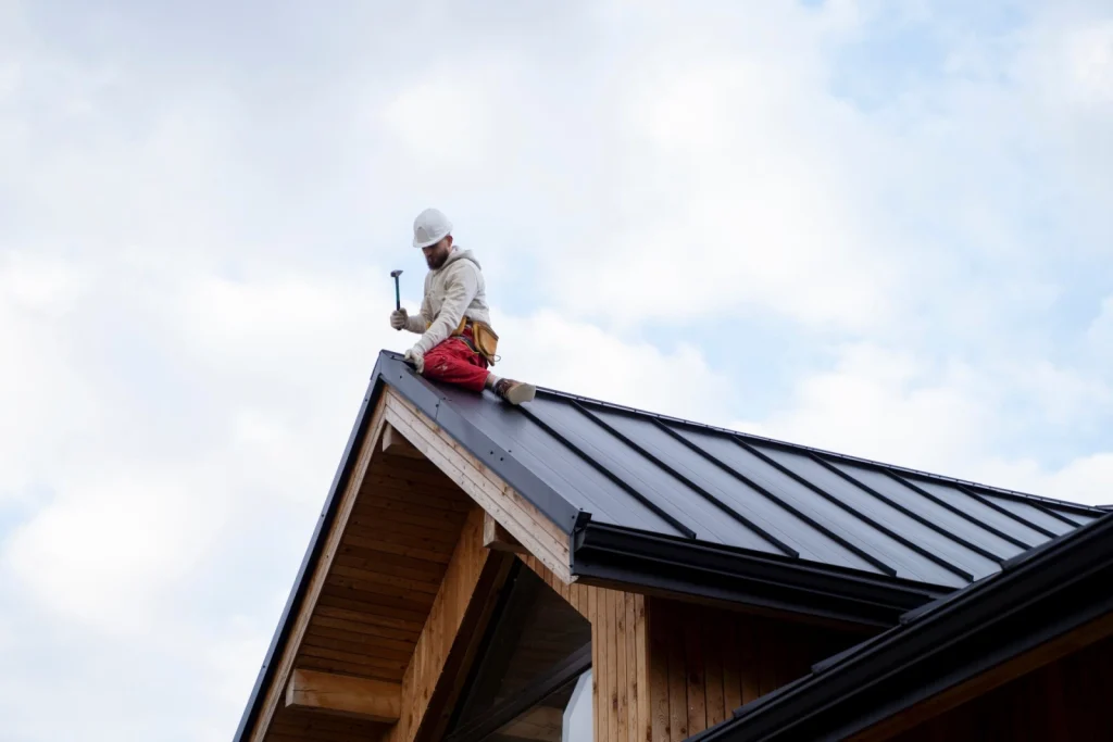 Experienced roofer completing standing seam metal roof repairs during roof leak repairs in Leederville.