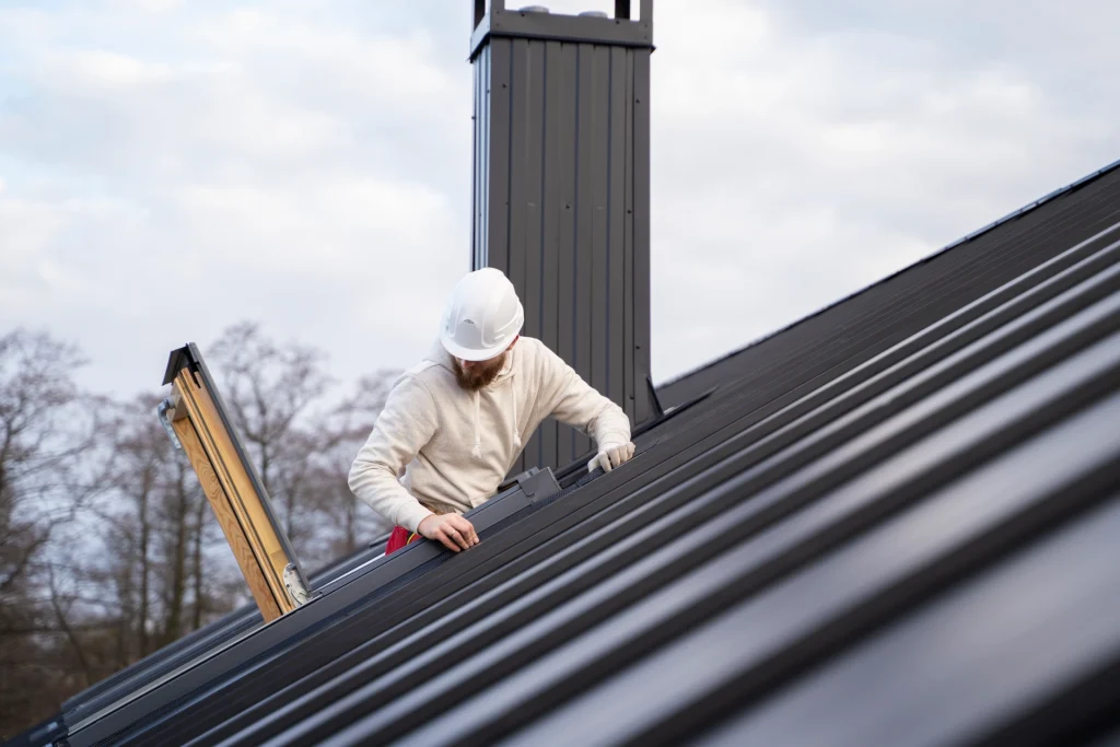 Professional roofer inspecting and repairing a metal roof during roof leak repairs in Victoria Park.